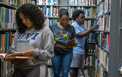 Students at the Albert A. Sheen Campus Browse through Books in the Library