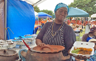 A participant shares food with members of the Community on World Food Day.