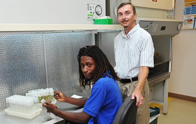 University of the Virgin Islands Assistant Director of Agricultural Experiment Station Thomas Zimmerman assists student.