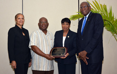 School of Education Professors Dr. Nancy Morgan,  Dr. Dennis Griffith and Dean Dr. Linda Thomas accept presidential award from UVI President Dr. David Hall.