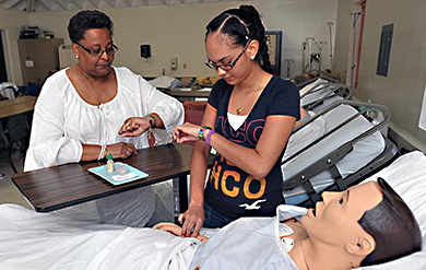 University of the Virgin Islands nursing student and instructor work with mannequin on the Albert A Sheen Campus on Saint Croix 