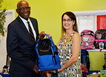 UVI President David Hall presents a backpack to Dana Holtz, Queen Louise Home for Children director. 