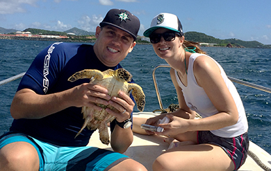 Scott Eanes, left, poses with turtle near Hawsbill Cove.