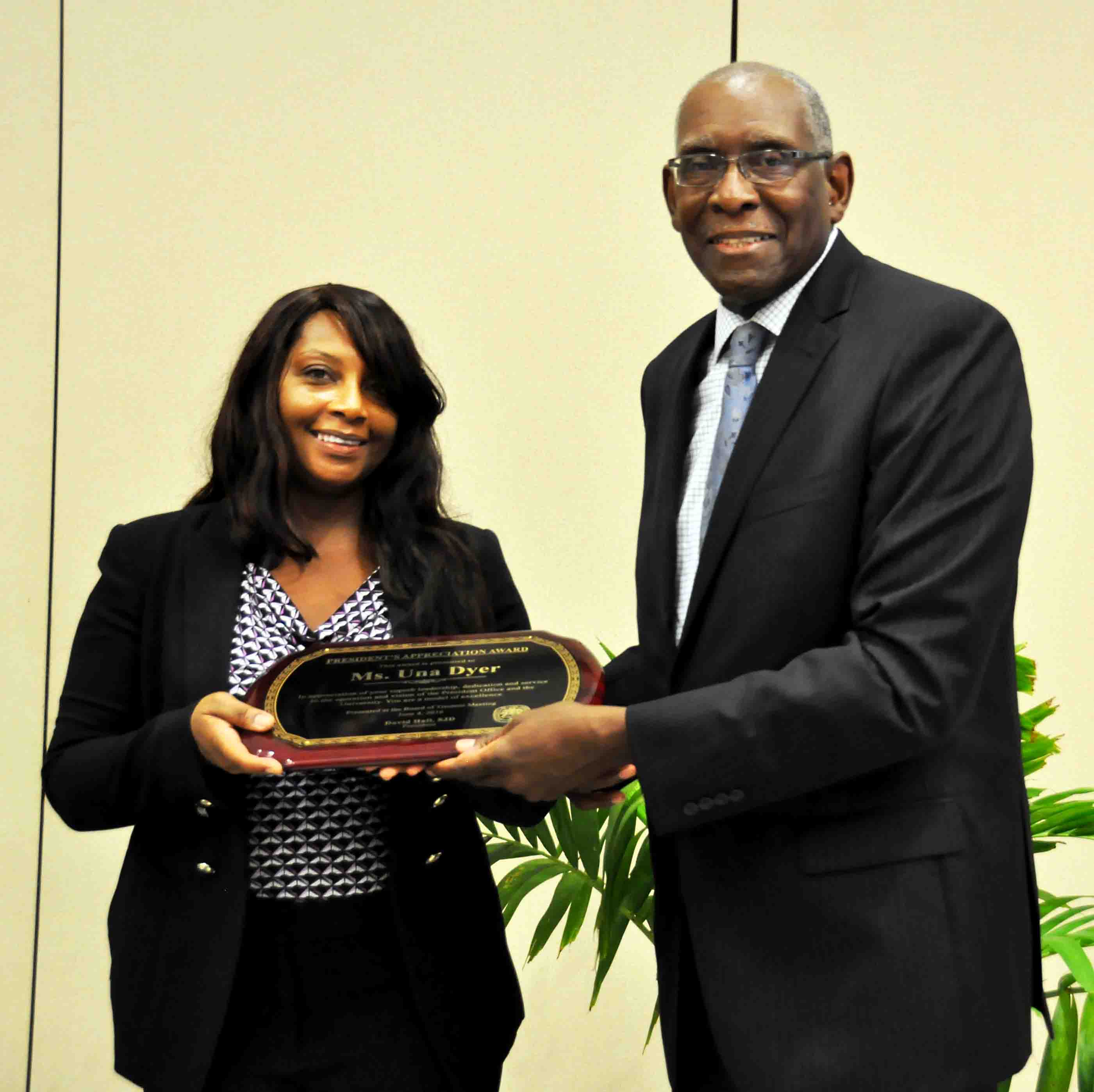 Una Dyer accepts award from UVI President David Hall