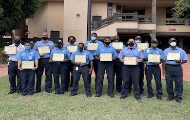 Students showcasing their Certificates of Completion on the grounds of UVI’s Albert A. Sheen Campus