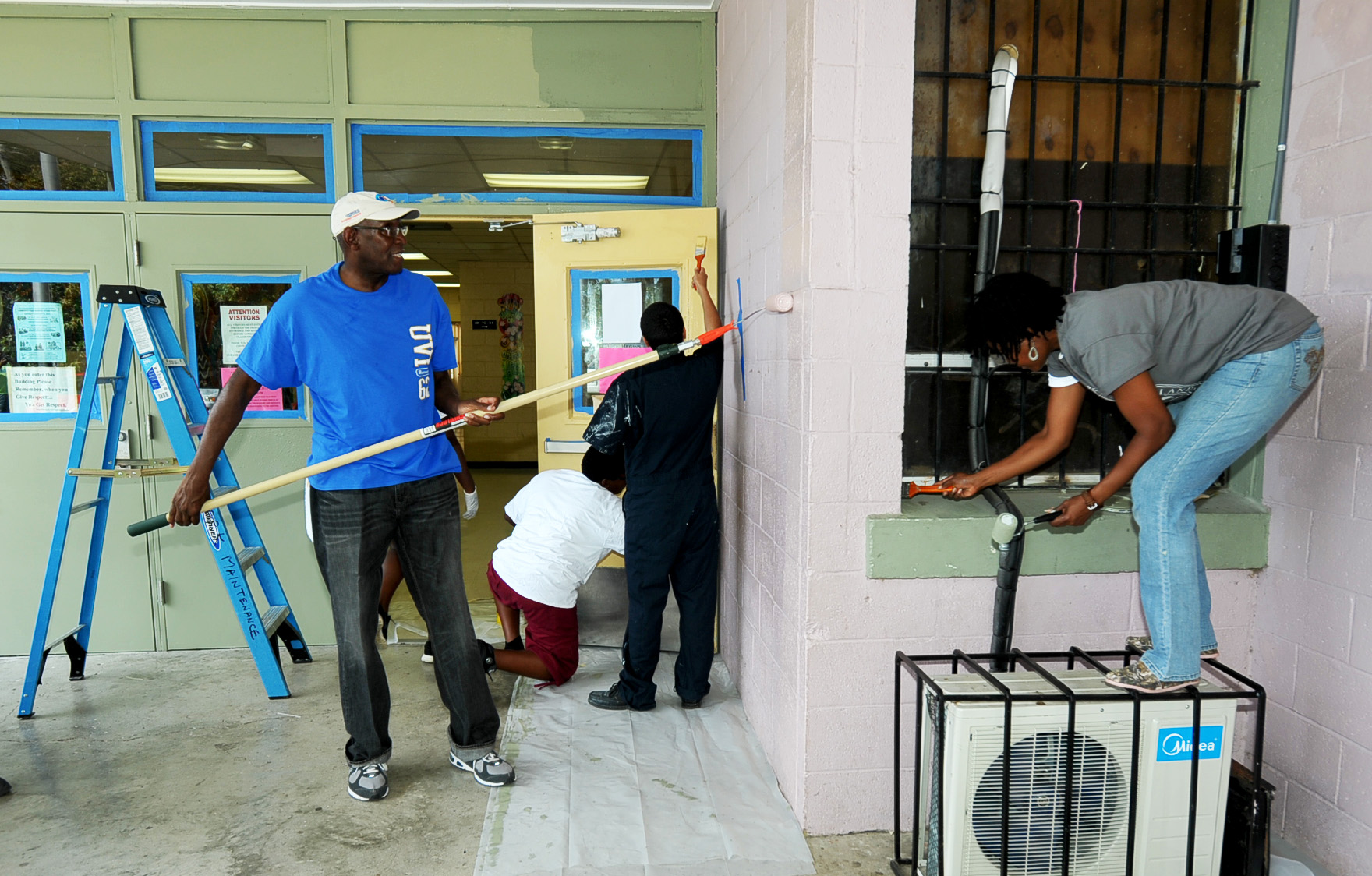 UVI President David Hall and other UVI volunteers paint the Alexander Henderson Elementary School. 